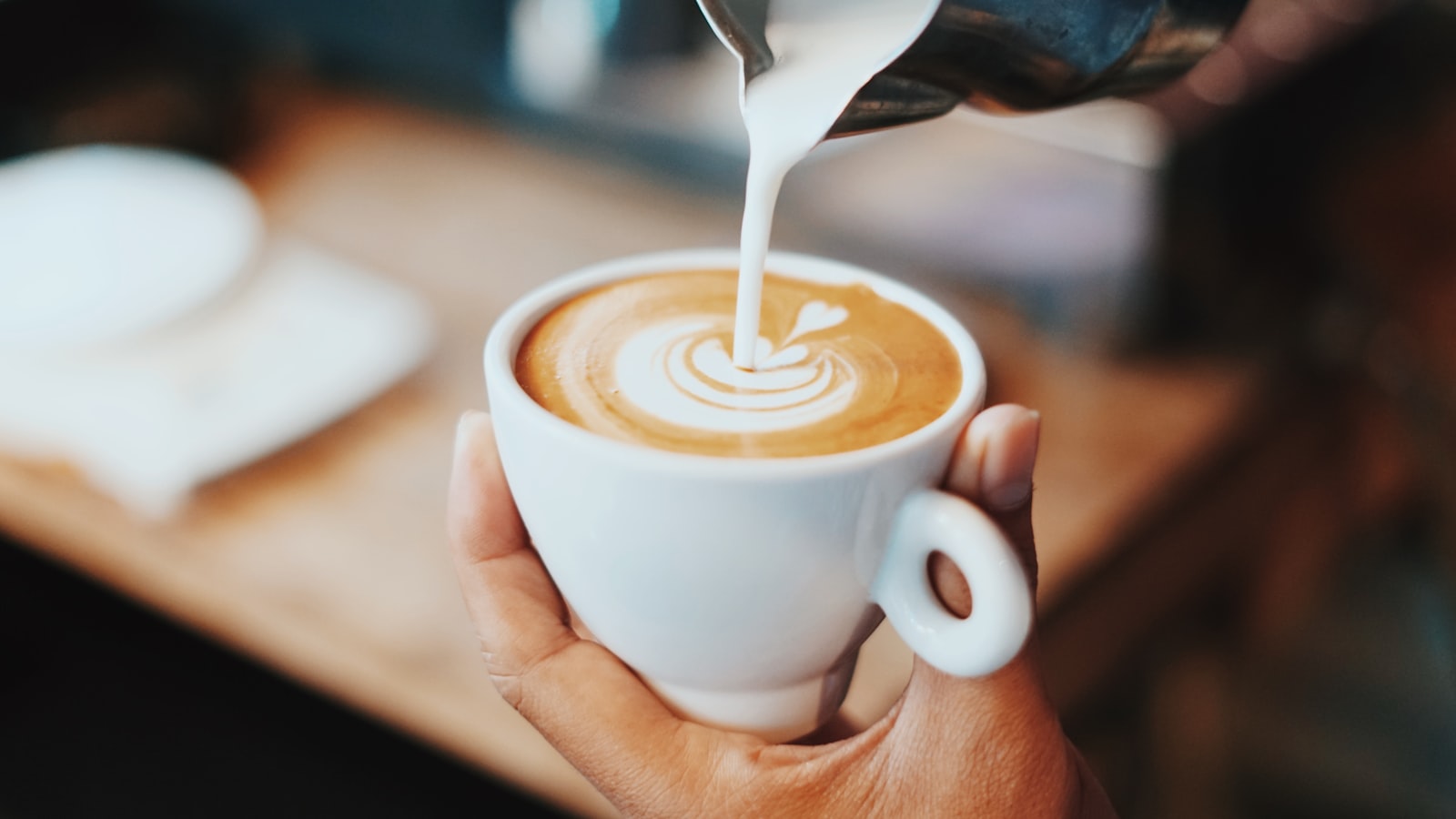 A latte with a poured rosetta pattern in the foam